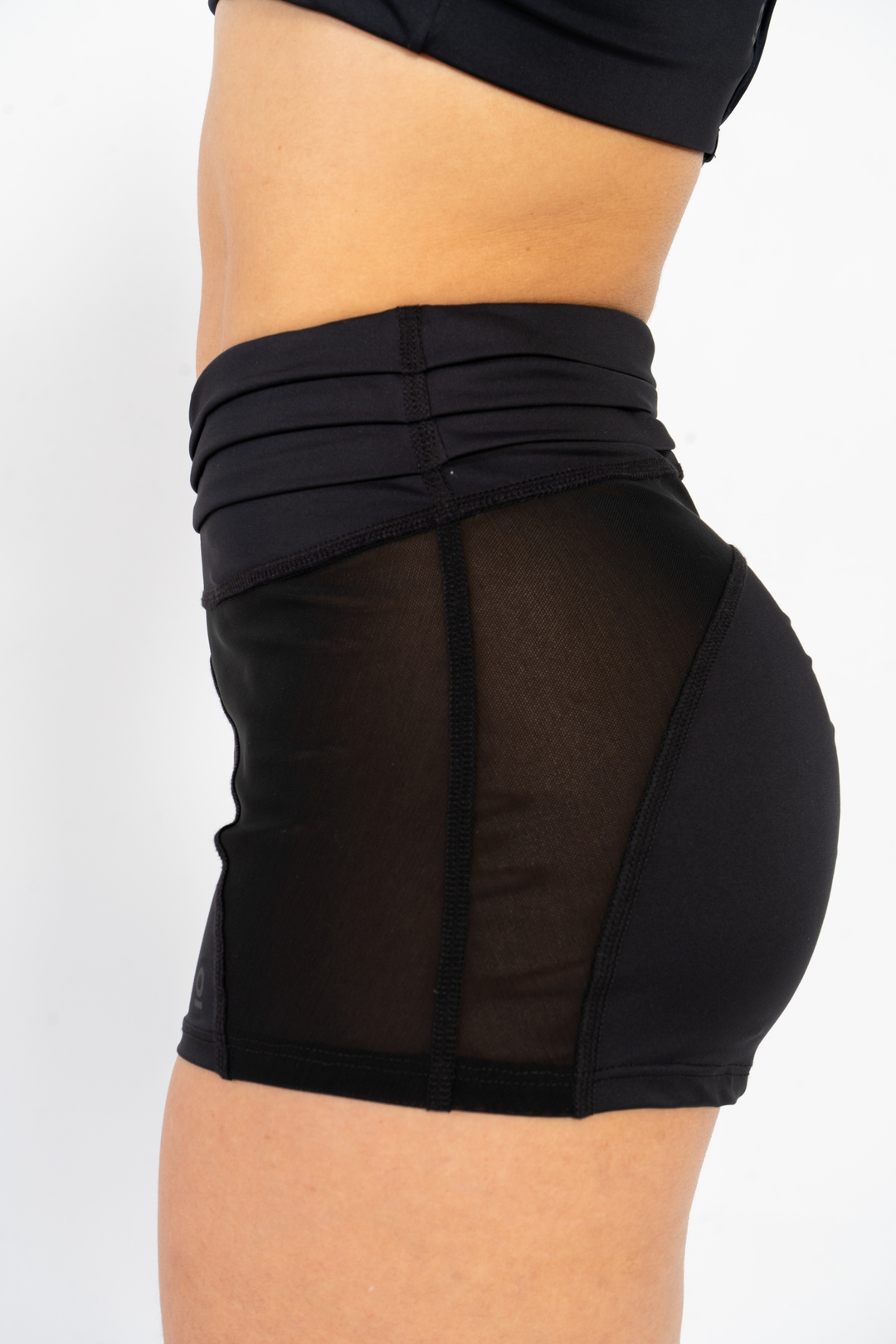 Black athletic shorts with mesh panels on a white background 