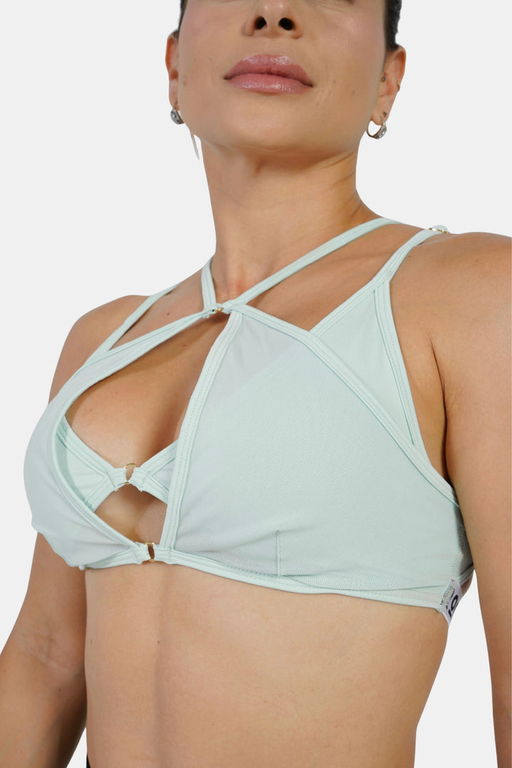 Light green bikini top worn by a model on a white background #color_mint