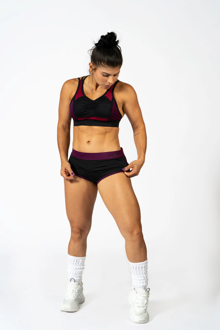 Woman in athletic wear posing on a white background. #color_black-magenta