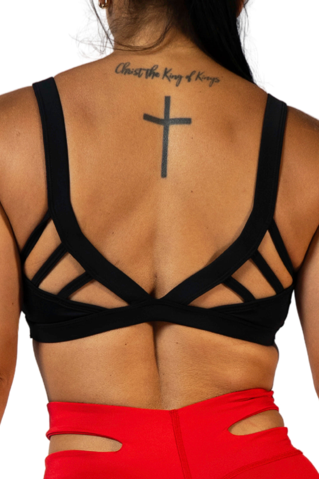Woman wearing the Meg sports bra with stylish back #color_black